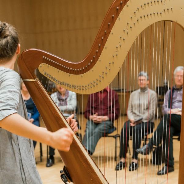 Frau spielt eine Harfe